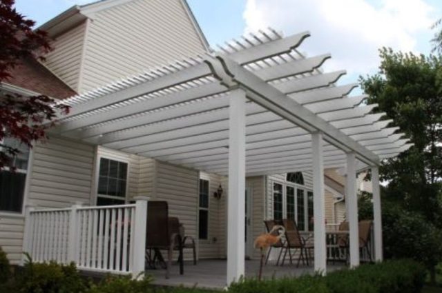 white vinyl pergola attached to wall of home and over deck area
