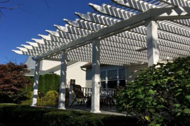 white vinyl pergola with square posts attached to home