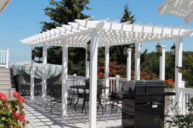 white vinyl pergola and railings around a two story deck attached to home
