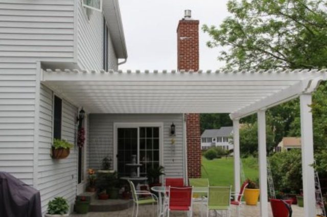 white vinyl pergola attached to a home and over a front porch