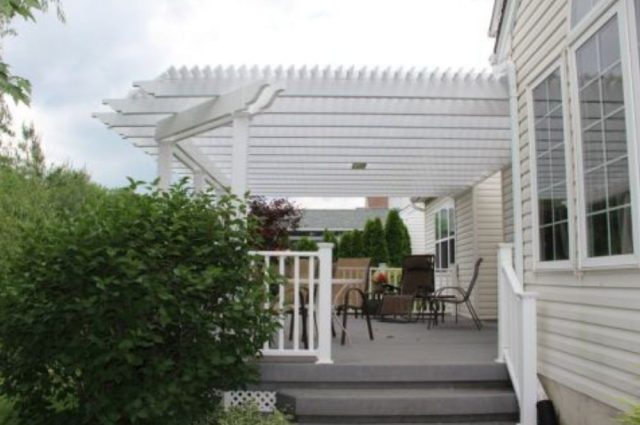 white vinyl pergola over a deck with white vinyl railing around the deck