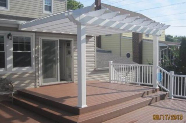 attached white vinyl pergola over deck area around the back of a home