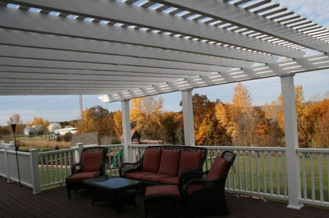 outdoor furniture on a deck with a vinyl pergola over the top and vinyl railing around the outside
