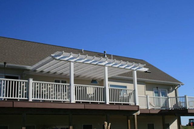 white vinyl pergola and railings around two story deck attached to home