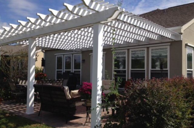 white vinyl pergola wall mounted to home and over patio area