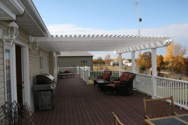 white wall mounted vinyl pergola over deck area with outdoor furniture
