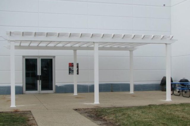 large vinyl pergola over the entrance to an commercial building