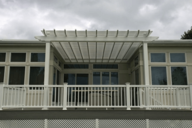 white vinyl pergola attached to a home over a two story deck that has white railing around it