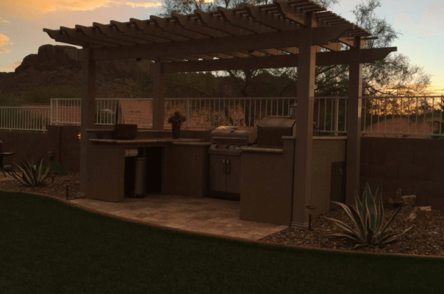 vinyl detached pergola at sunset over an outdoor kitchen in a residential backyard