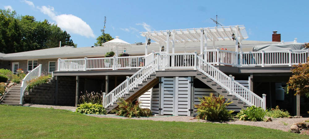 freestanding white pergola placed on two story deck attached to home