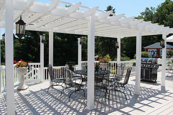 large pergola shown with elegant dining set and grill 