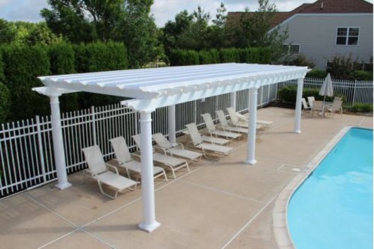 extra large pergola shown by the pool with deck chairs