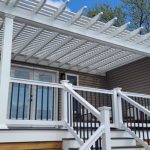 white attached vinyl pergola over a two story deck with white railings around the outside