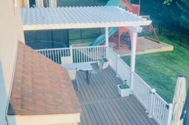 white vinyl deck railing around wooden deck and pergola over top